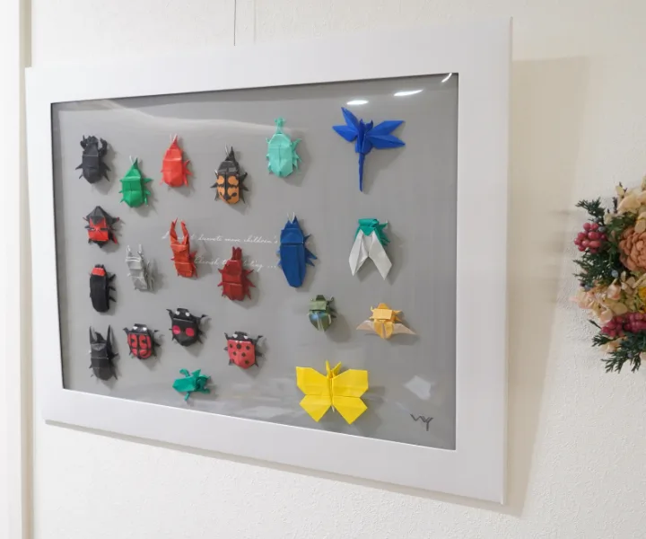 ペーパーフレームに折り紙の昆虫20体以上を並べて壁に飾った作品