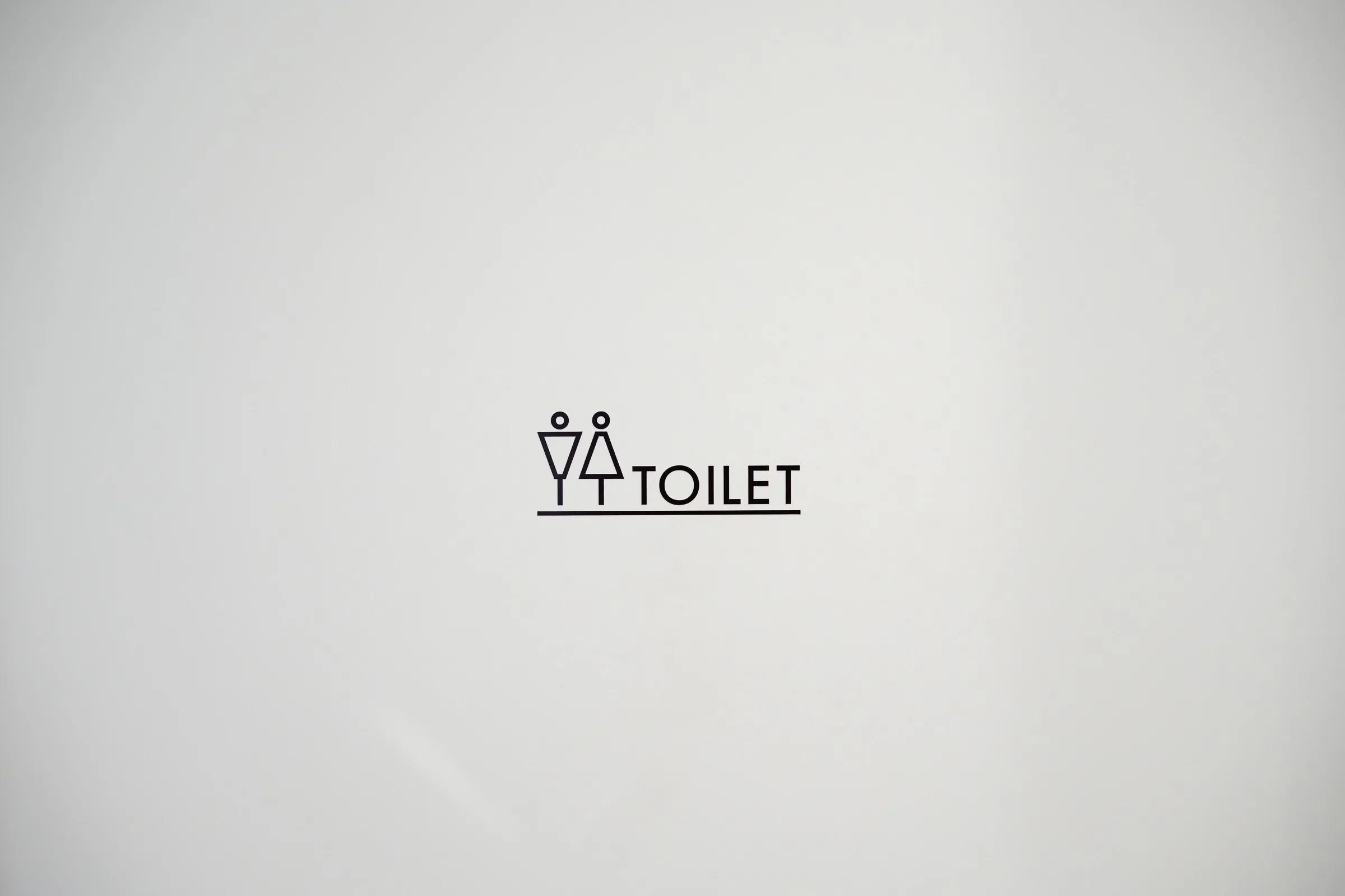 グレー背景に男女ピクトグラムとTOILET文字の横タイプサインステッカーデザイン