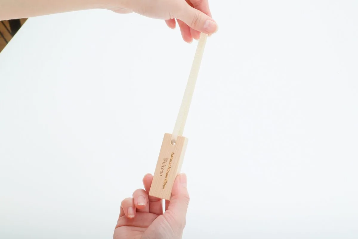「Natural Hinoki Block / Kitoen」刻印入りの国産ヒノキ無垢材ブロック消臭剤を手で持つ