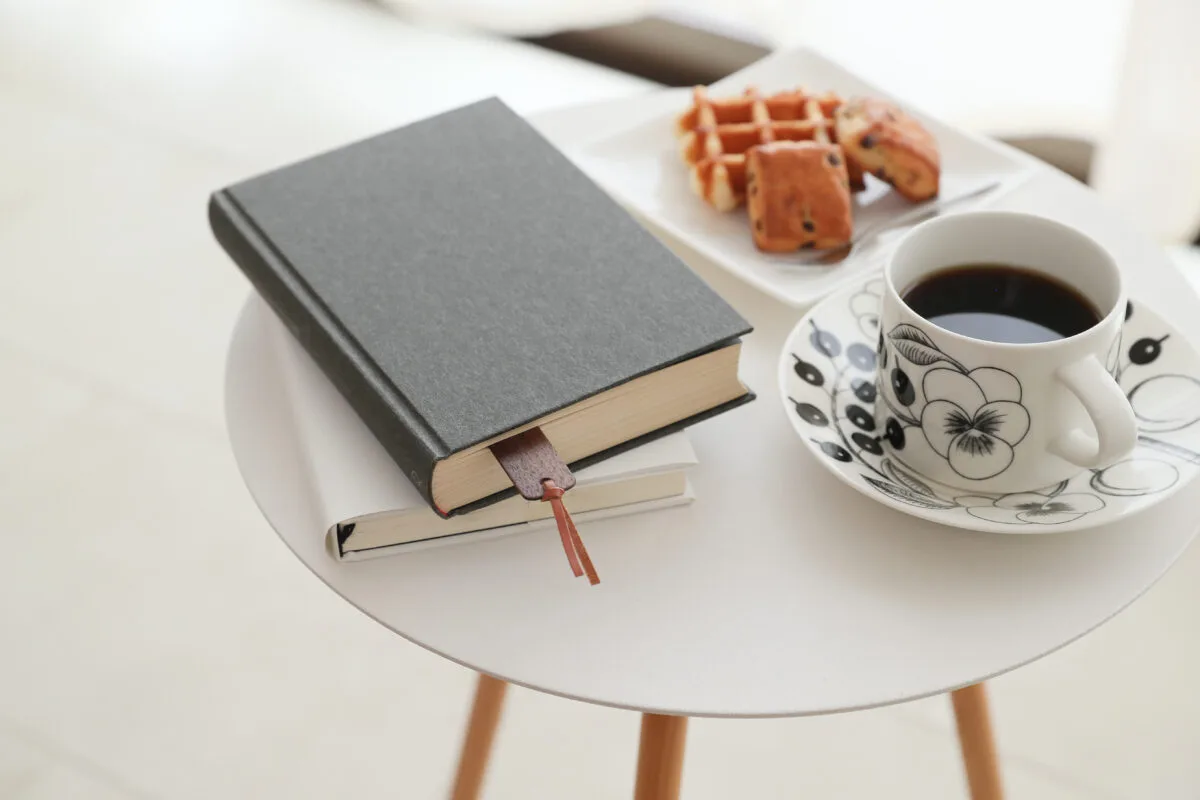 しおり付きの本・コーヒー・ワッフルがテーブルに並んだくつろぎの読書シーン