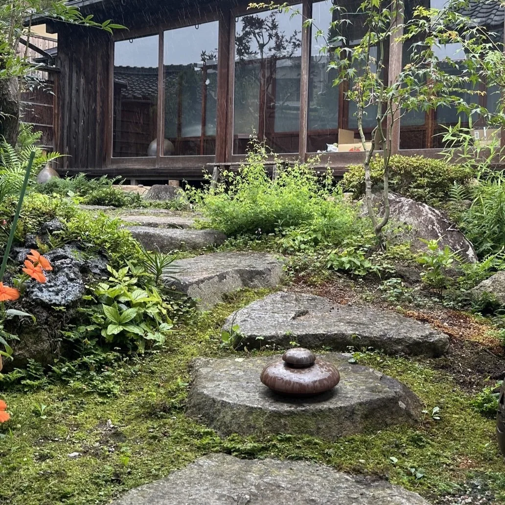 日本家屋の苔むした庭石の上に置かれた備前焼蚊遣り、和風の庭園でインテリアとして使用する様子