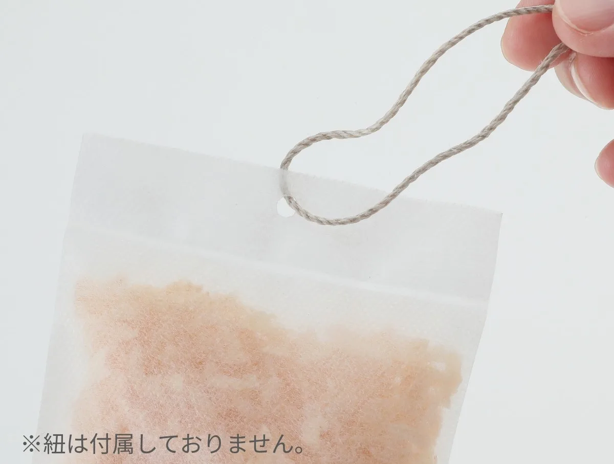 ヒノキ消臭・除湿剤パックの穴に紐を通して吊るせる仕様のアップ(紐は別売り)