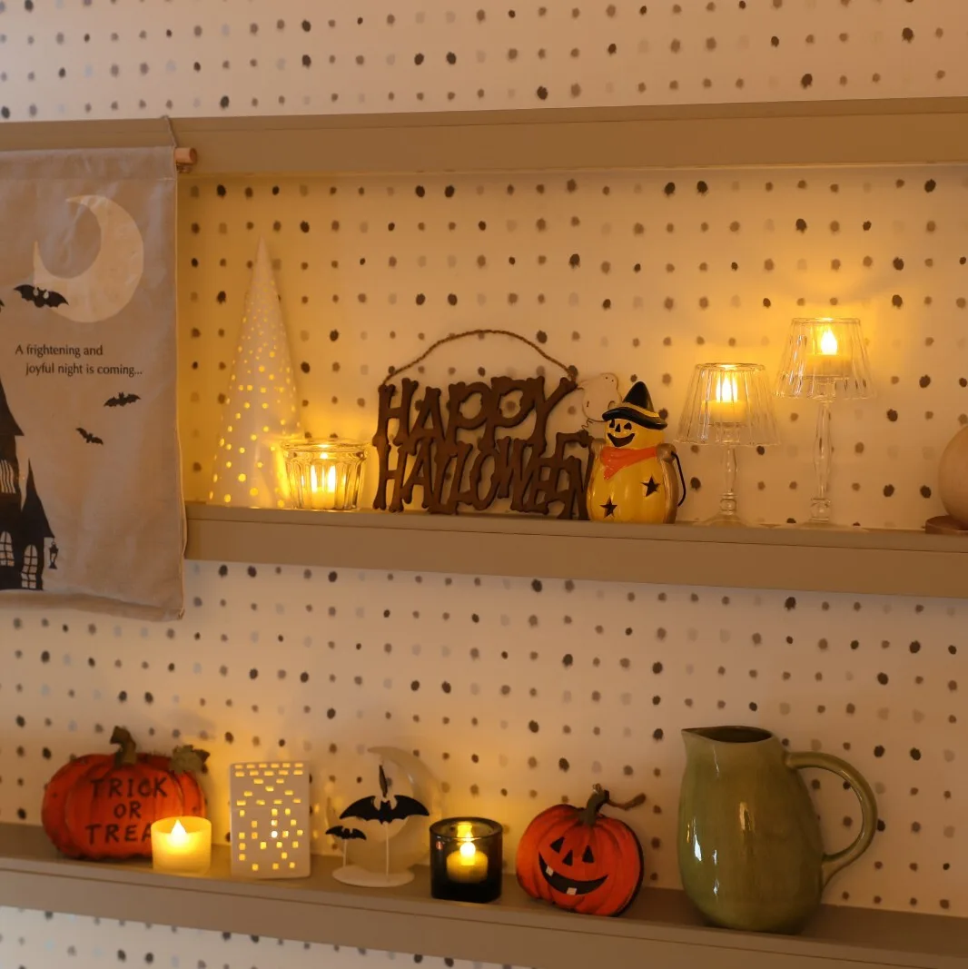 HAPPY HALLOWEENの木製看板・カボチャ・LEDキャンドルを棚に飾ったハロウィンインテリア