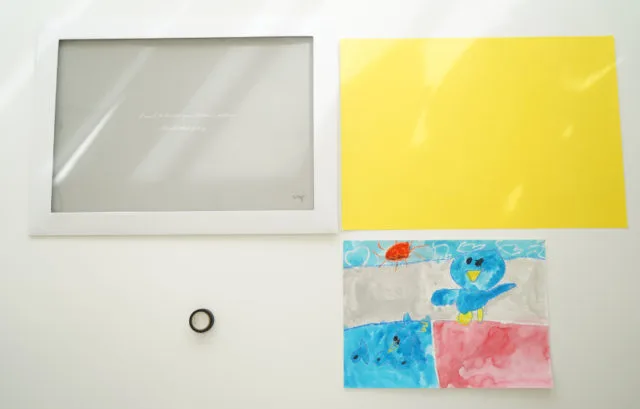 ペーパーフレーム本体・黄色色画用紙・ペンギンの子供の絵を並べた材料一覧