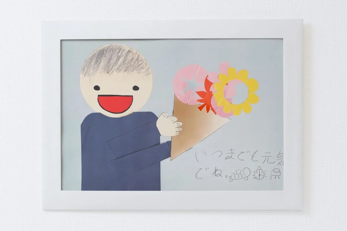 子どもが作った切り絵「いつまでも元気でね」のメッセージ付き作品をホワイトフレームに飾ったプリント仕上がり例